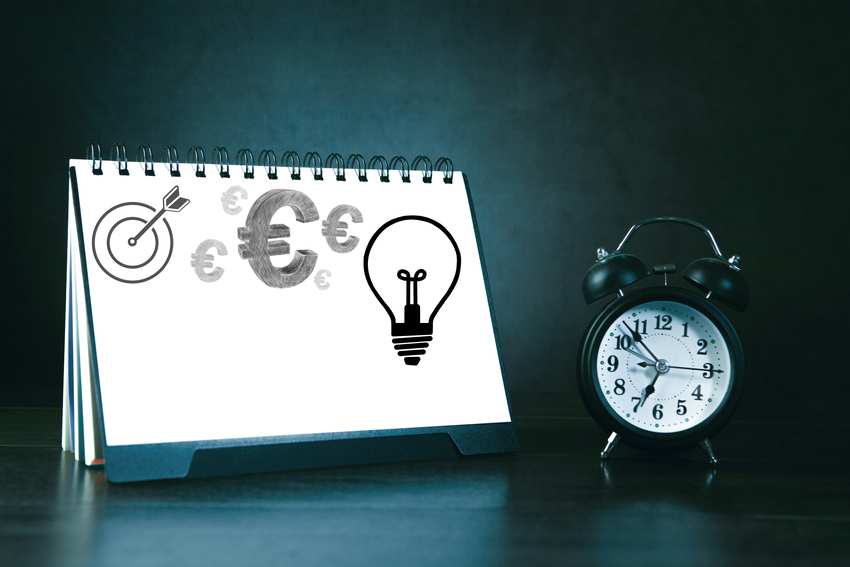Investment planning notebook with euro symbols and clock